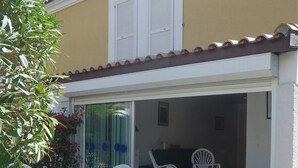 A covered patio with white plastic furniture, a table, and chairs. - VILLA  3 ROOMS MEZ 57m2 + TERRACE 11m2 REF 4036 (MARSEILLAN PLAGE)