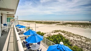 A balcony with blue umbrellas and chairs overlooking a beach. - Walk to Wildwood Beach: Oceanfront Condo w/ View (Wildwood Crest)