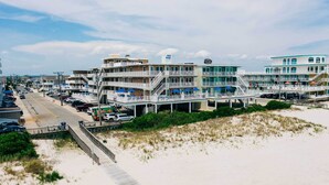 A beachfront hotel with multiple balconies, a boardwalk, and a sandy beach. - Walk to Wildwood Beach: Oceanfront Condo w/ View (Wildwood Crest)