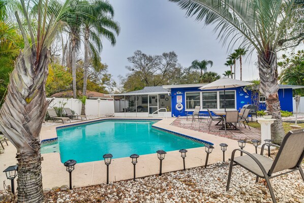 Relax by the pool surrounded by comfortable seating and lush greenery.