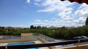 Un espace piscine offrant une vue dégagée sur le paysage environnant, notamment sur les maisons et la végétation.