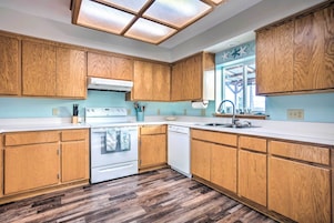 Una cocina moderna con armarios de madera, una estufa blanca y un lavavajillas.