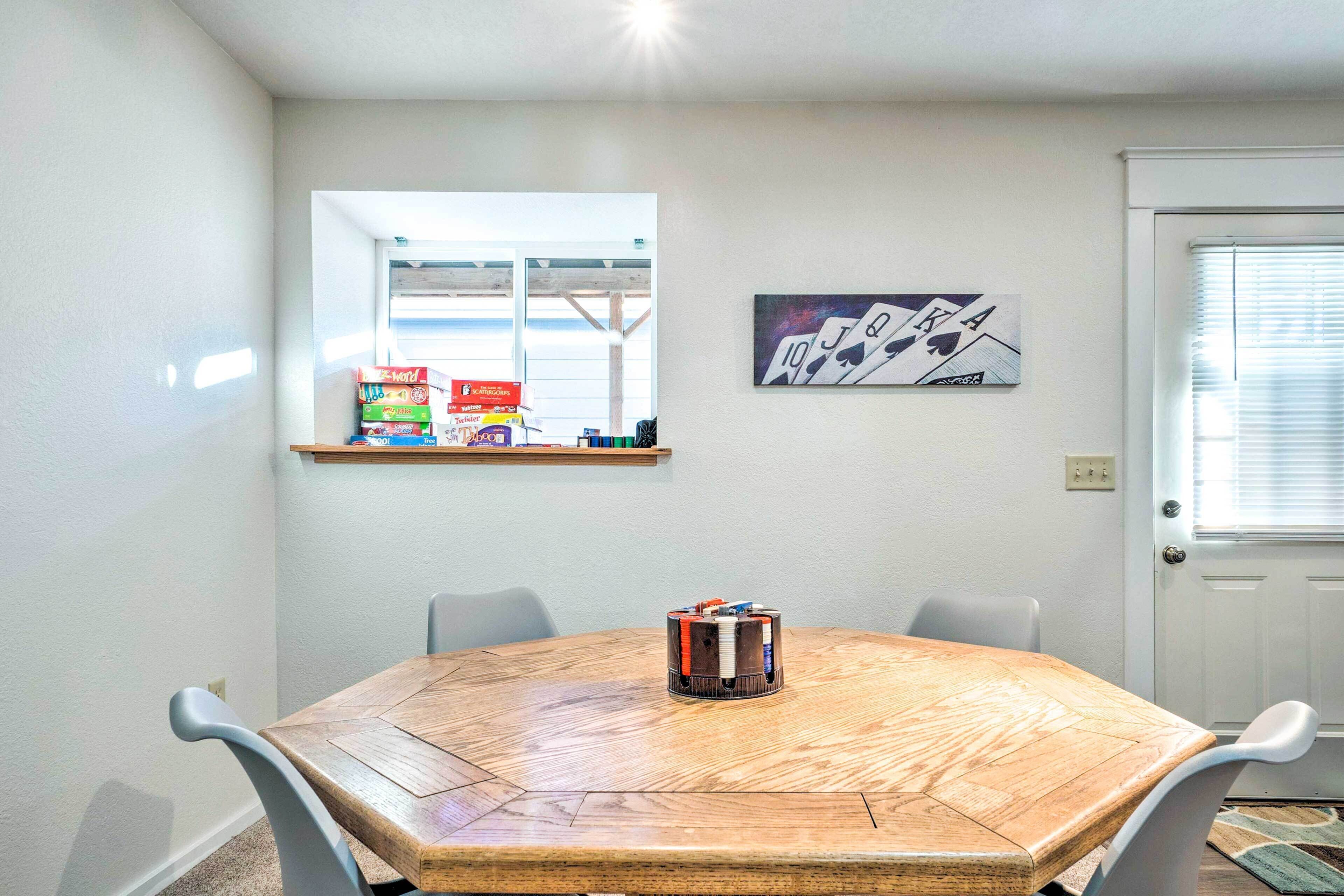 A dining area with a wooden table, chairs, a window, and a door.