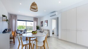 A modern, open-plan living space with a dining area, a kitchen, and a bedroom.