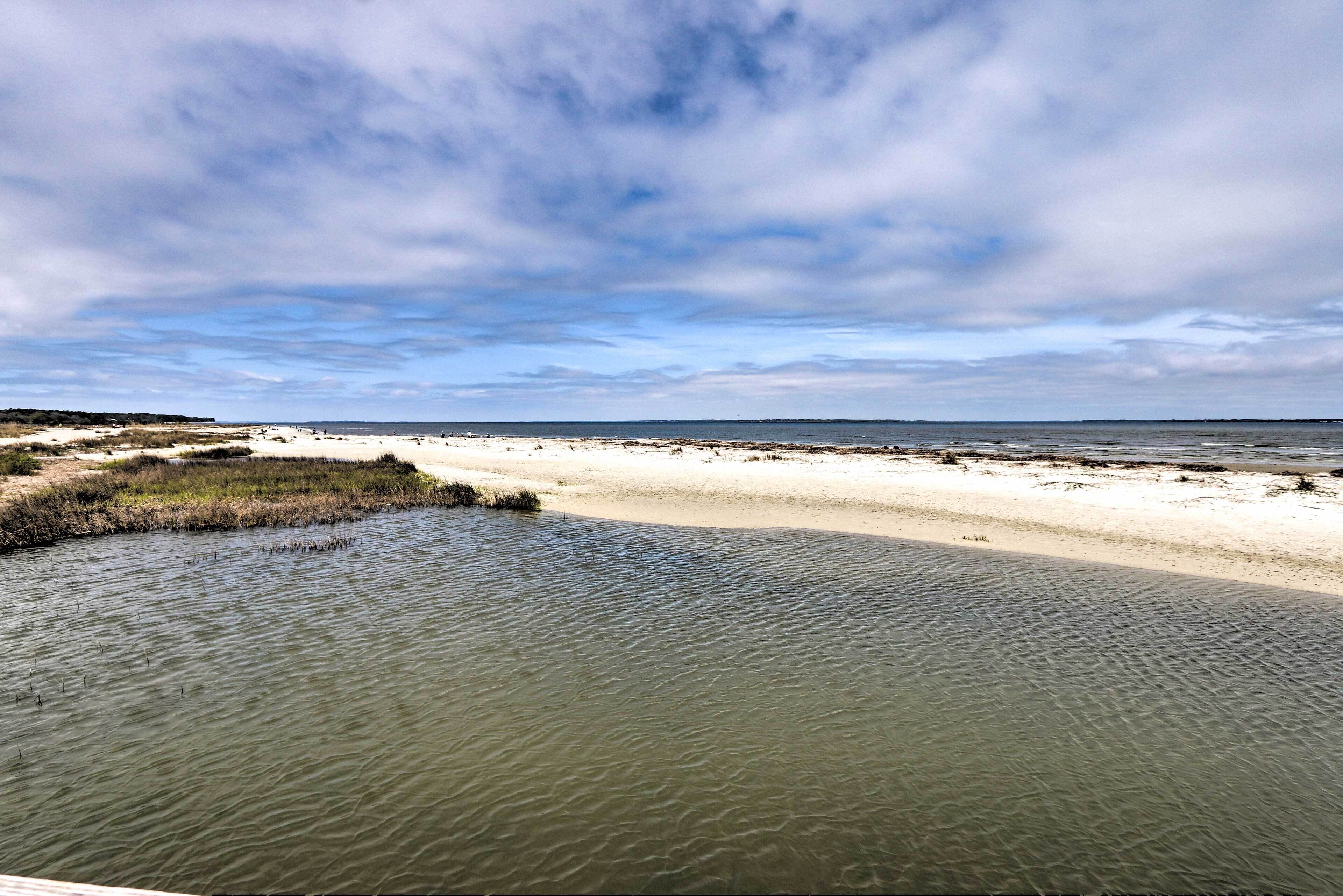 Une plage à l’eau claire, avec un rivage sablonneux et un horizon lointain.