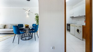 Eine moderne Küche mit Waschmaschine und Essbereich, inklusive Tisch und Stühlen.