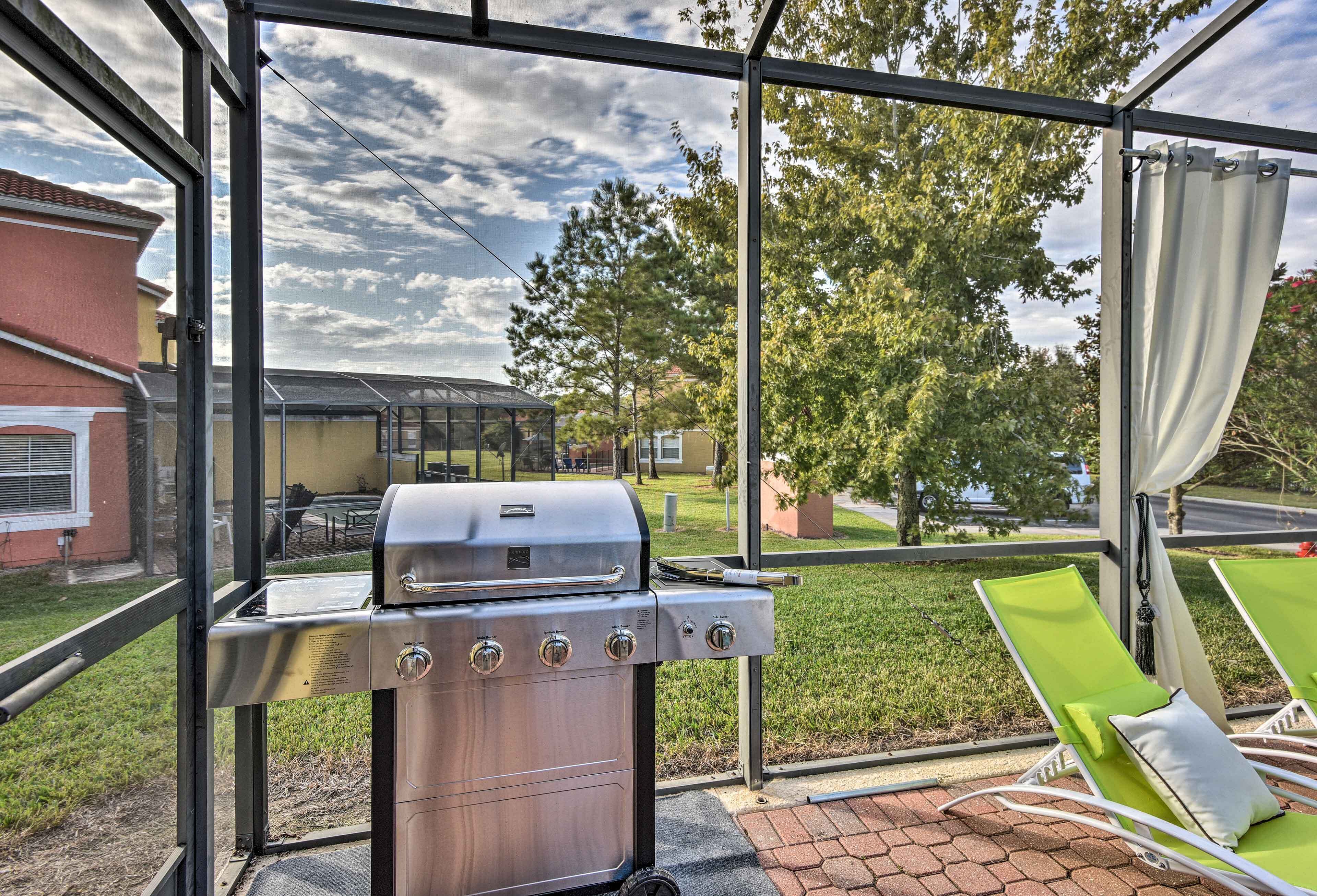 A covered patio with a grill, outdoor seating, and a view of a residential area.
