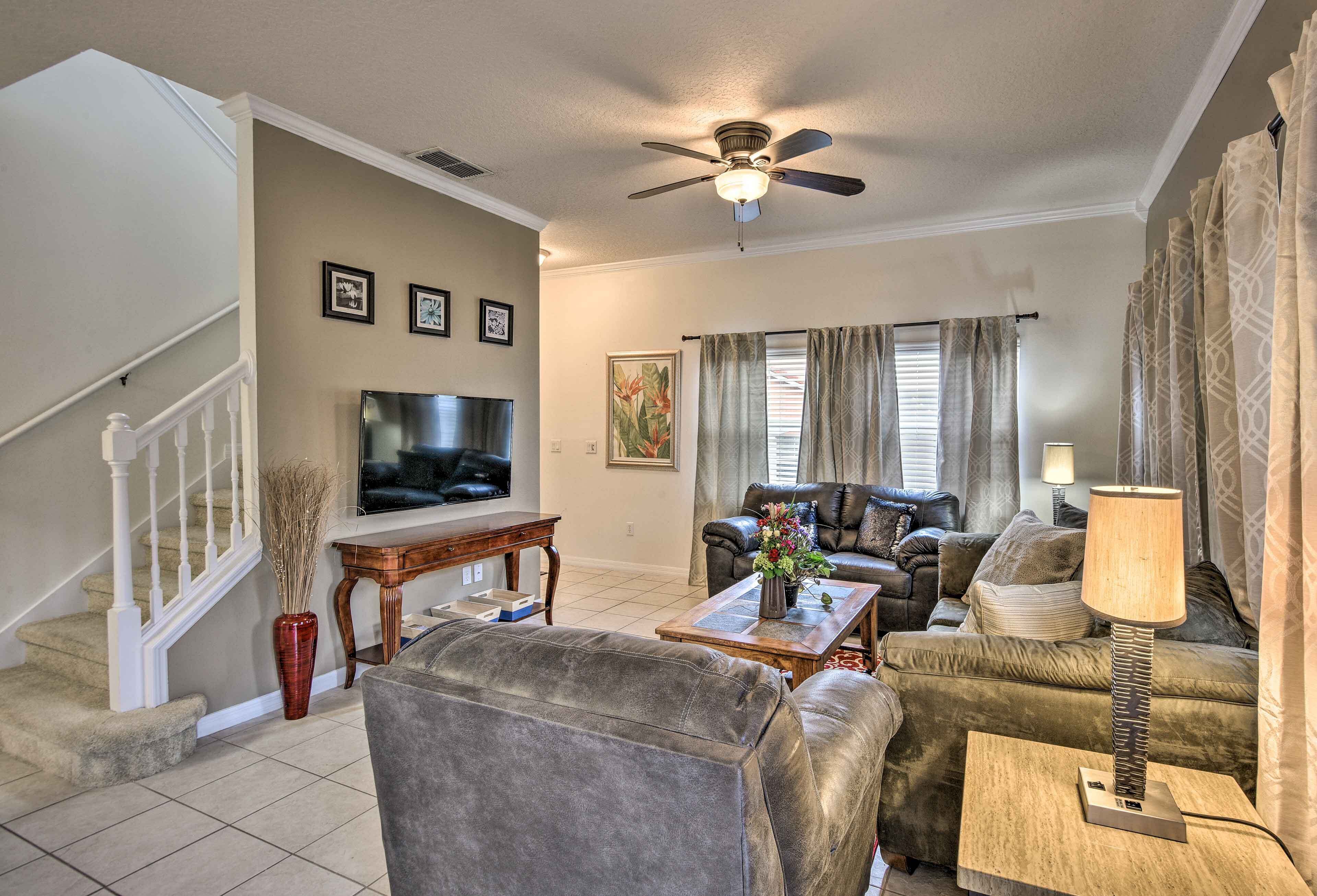 A living room with a sofa, coffee table, TV, and a staircase.