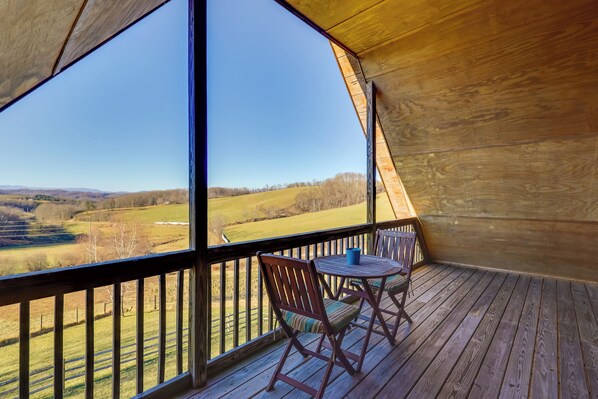 Una terraza de madera con vistas a un paisaje rural.