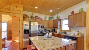A modern kitchen with wooden cabinets, granite countertops, stainless steel appliances, and a central island. - Decks, Panoramic Views! Mtn Retreat in Sparta (Sparta)