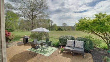 Enjoy al fresco dining and outdoor cooking in this beautifully landscaped garden setting with a patio, table, chairs, and grill.