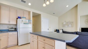 A modern kitchen with wooden cabinets, a built-in island, a refrigerator, and a toaster. - Ocean City Family Getaway ~ Qtr-mi to Beach! (Ocean City)