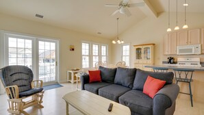 A spacious living room with a grey sofa, wooden rocking chair, and a white coffee table. - Ocean City Family Getaway ~ Qtr-mi to Beach! (Ocean City)