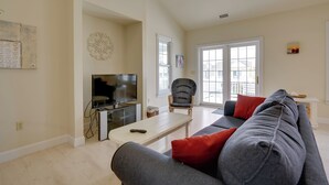 A living room with a grey sofa, a television, a white coffee table, and a window with a view. - Ocean City Family Getaway ~ Qtr-mi to Beach! (Ocean City)