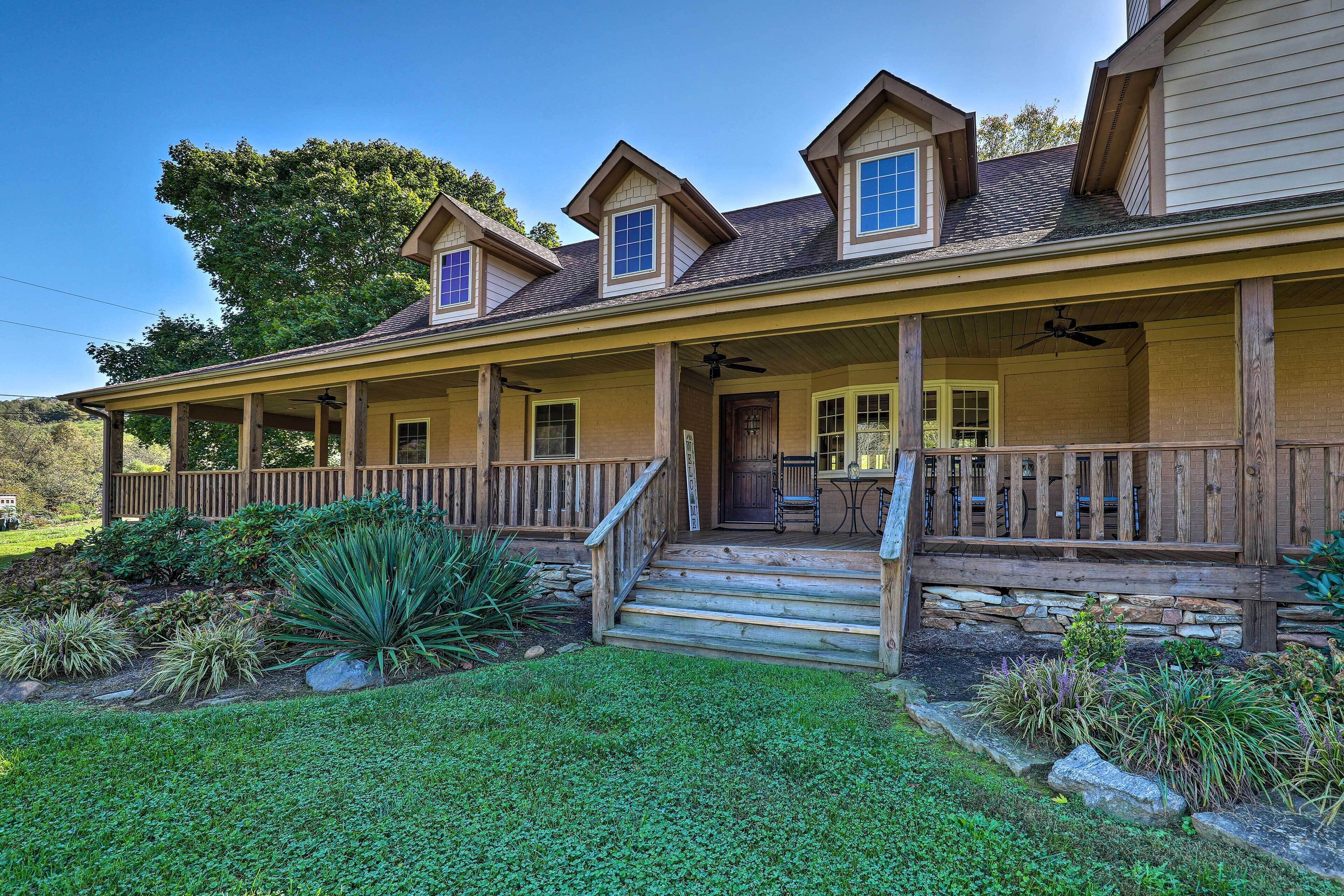 A two-story house with a covered porch, a front door, and a small patio area.