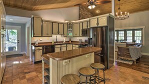 A spacious kitchen with wooden ceiling, granite countertops, and stainless steel appliances. - Game Room, Theater + Deck: Burnsville Cabin! (Burnsville)