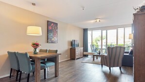 Un espacio habitable amplio con una mesa de comedor, sillas, un sofá y un televisor.