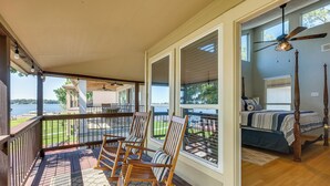 A covered porch with rocking chairs, a bed with a view, and a ceiling fan. - Lakefront Montgomery Home w/ Porch & Dock! (Montgomery)