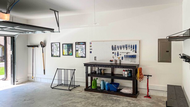 A garage with a pegboard wall, a workbench, and various tools. - New Everything! Comfy Home w/ Deck & Trail Access! (Bella Vista)