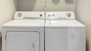 Een paar witte voorladers wasmachines en drogers in een wasserette.