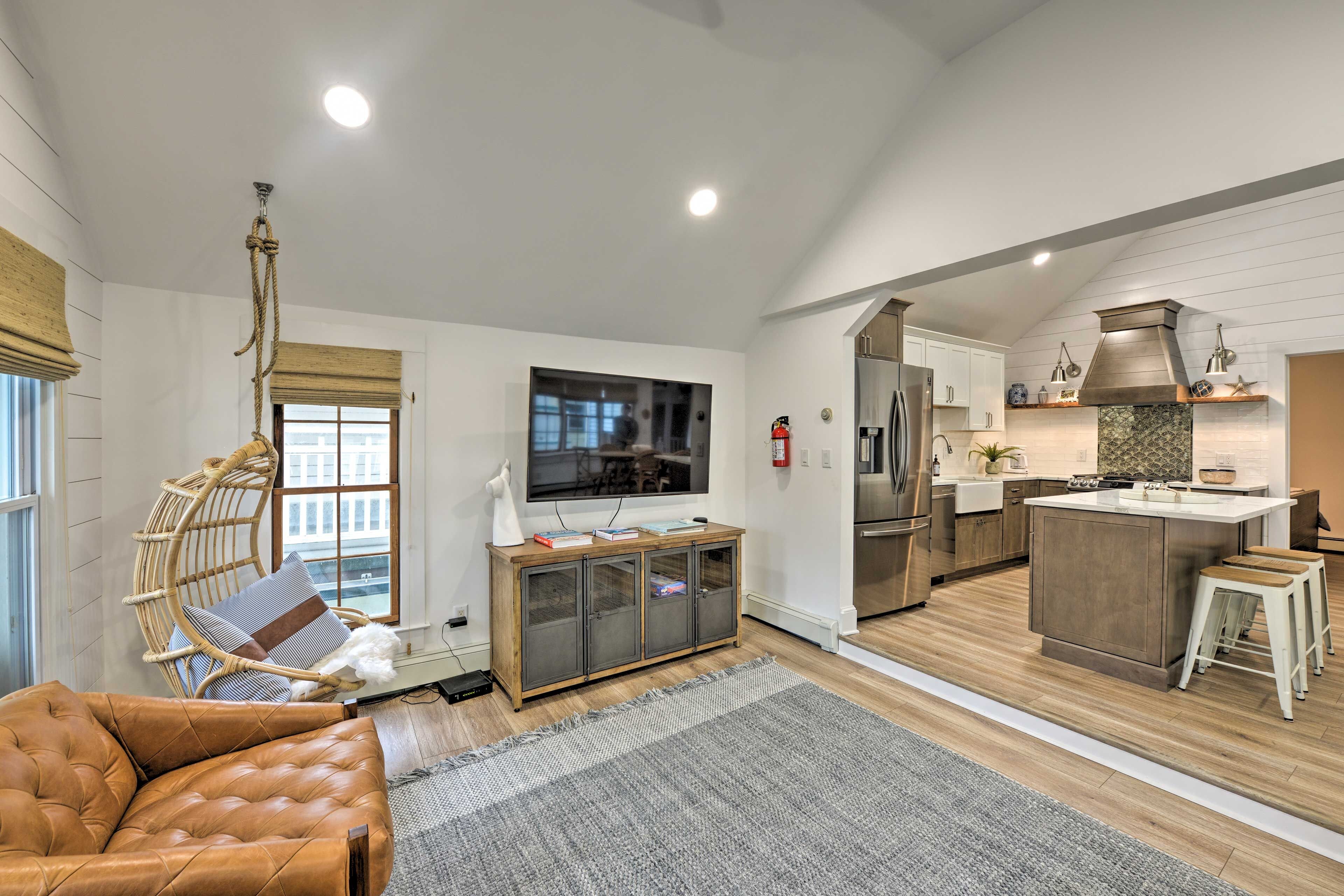 A modern living room with a leather sofa, a wooden entertainment unit, and a large flat-screen TV.