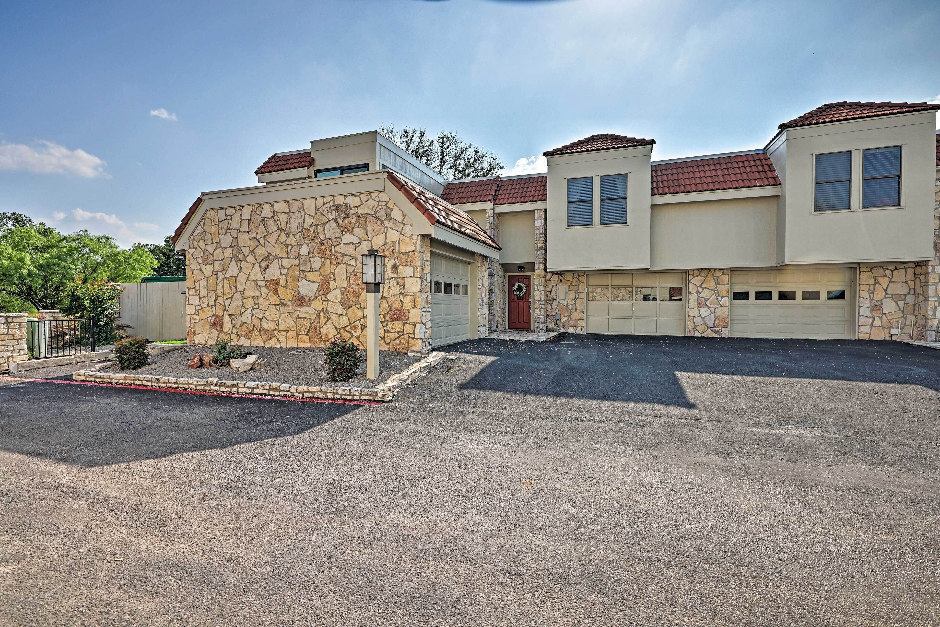 A two-story house with a stone facade, a garage, and a driveway.