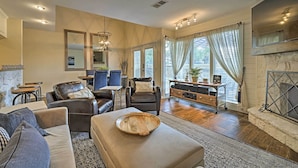 A modern living room with a fireplace, leather furniture, and a dining area with a table and chairs. - Modern Townhome w/ Patio, Next Door to Resort (Horseshoe Bay)