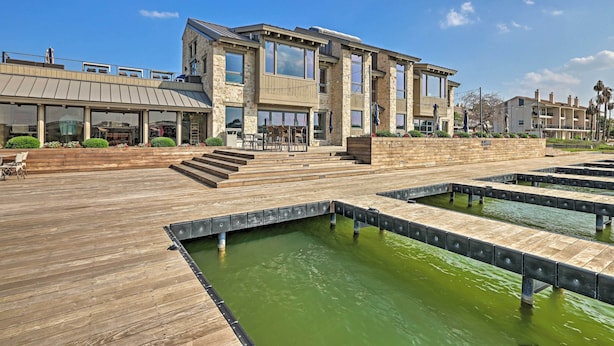 A modern building with a wooden deck and a water feature. - Modern Townhome w/ Patio, Next Door to Resort (Horseshoe Bay)