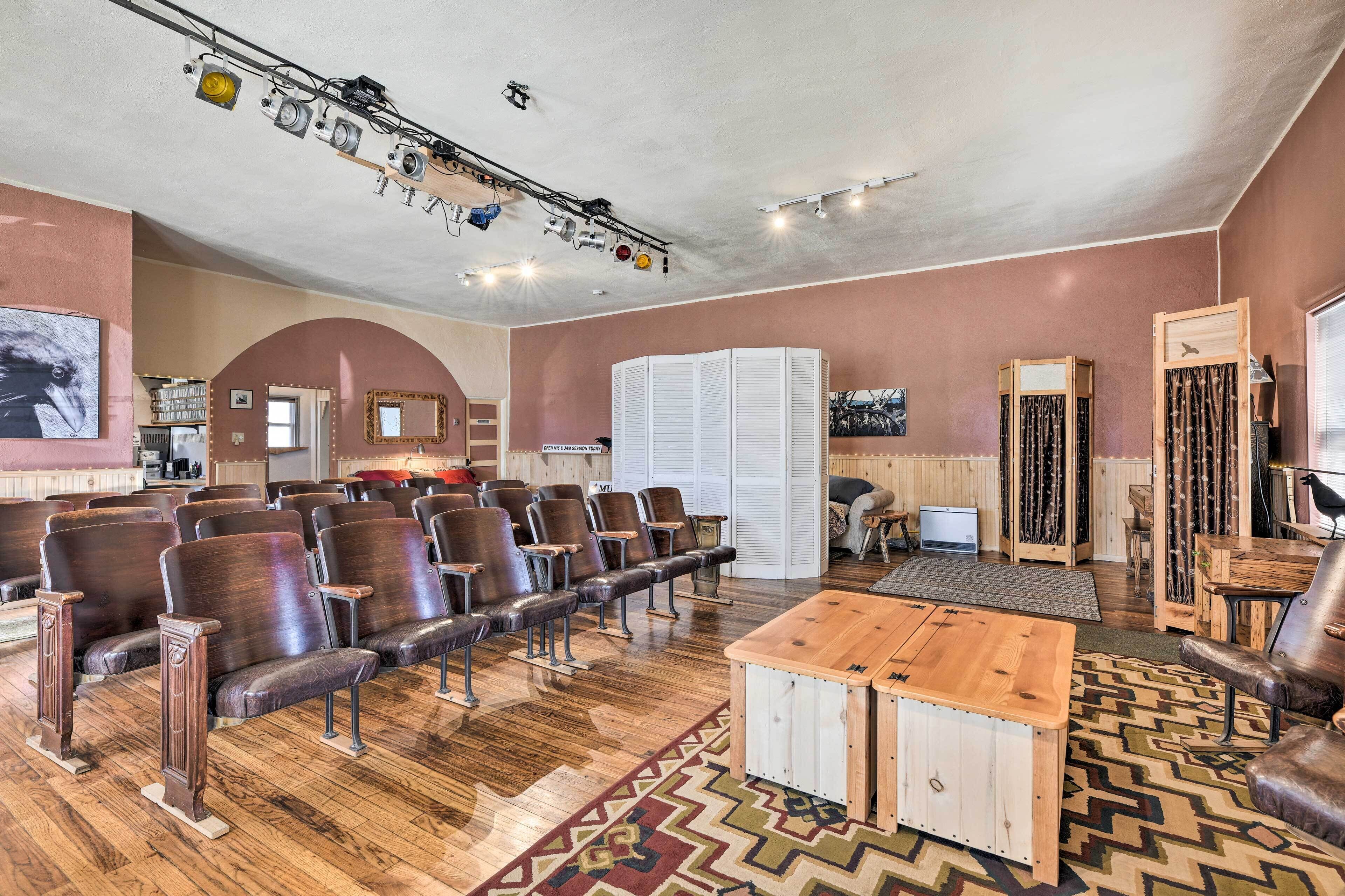 A spacious room with rows of leather chairs, a wooden coffee table, and a patterned rug.
