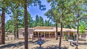 A building with a covered porch, surrounded by trees and a dry landscape. - House of Angels Retreat w/ Deck Near Winter Park (Ruidoso)