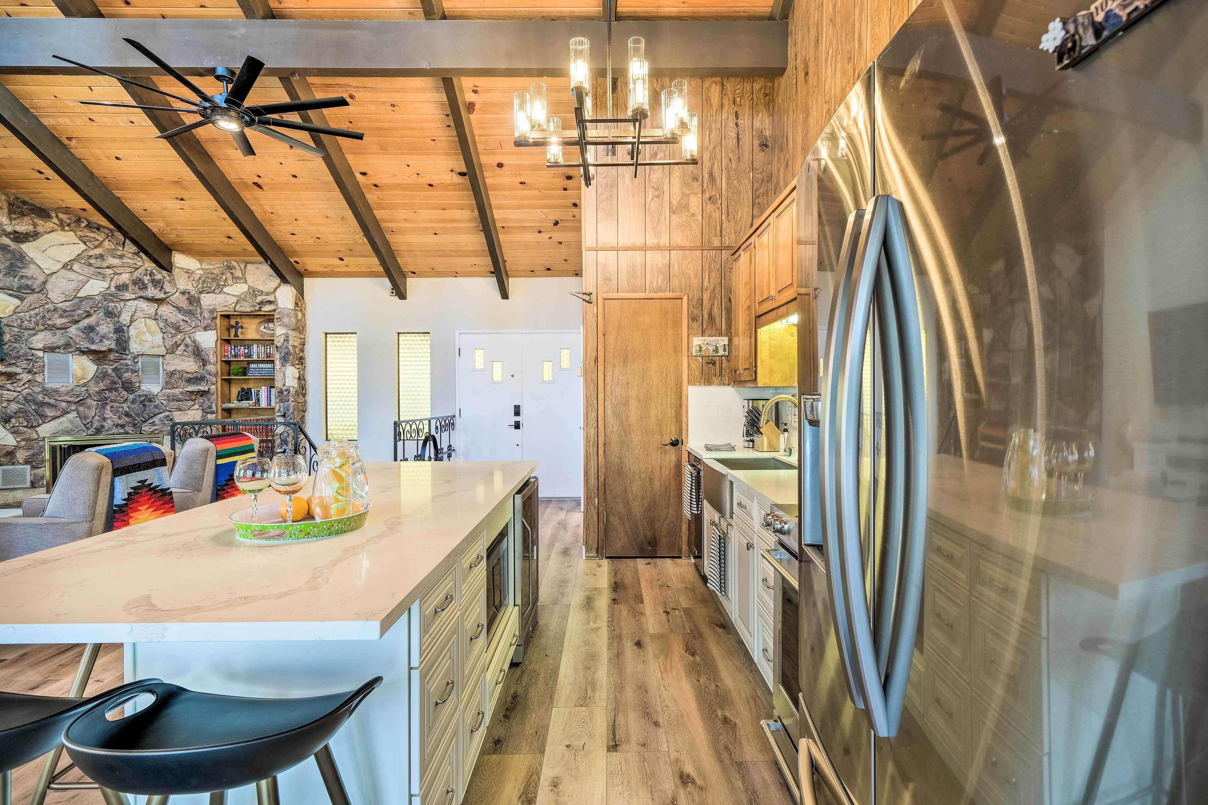 Una cocina moderna con un refrigerador de acero inoxidable grande, armarios de madera y una pared de acento de piedra.