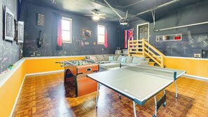 A room with a ping pong table, foosball table, and a sofa. - Richmond Area Home w/ Game Room & Patio! (Sandston)