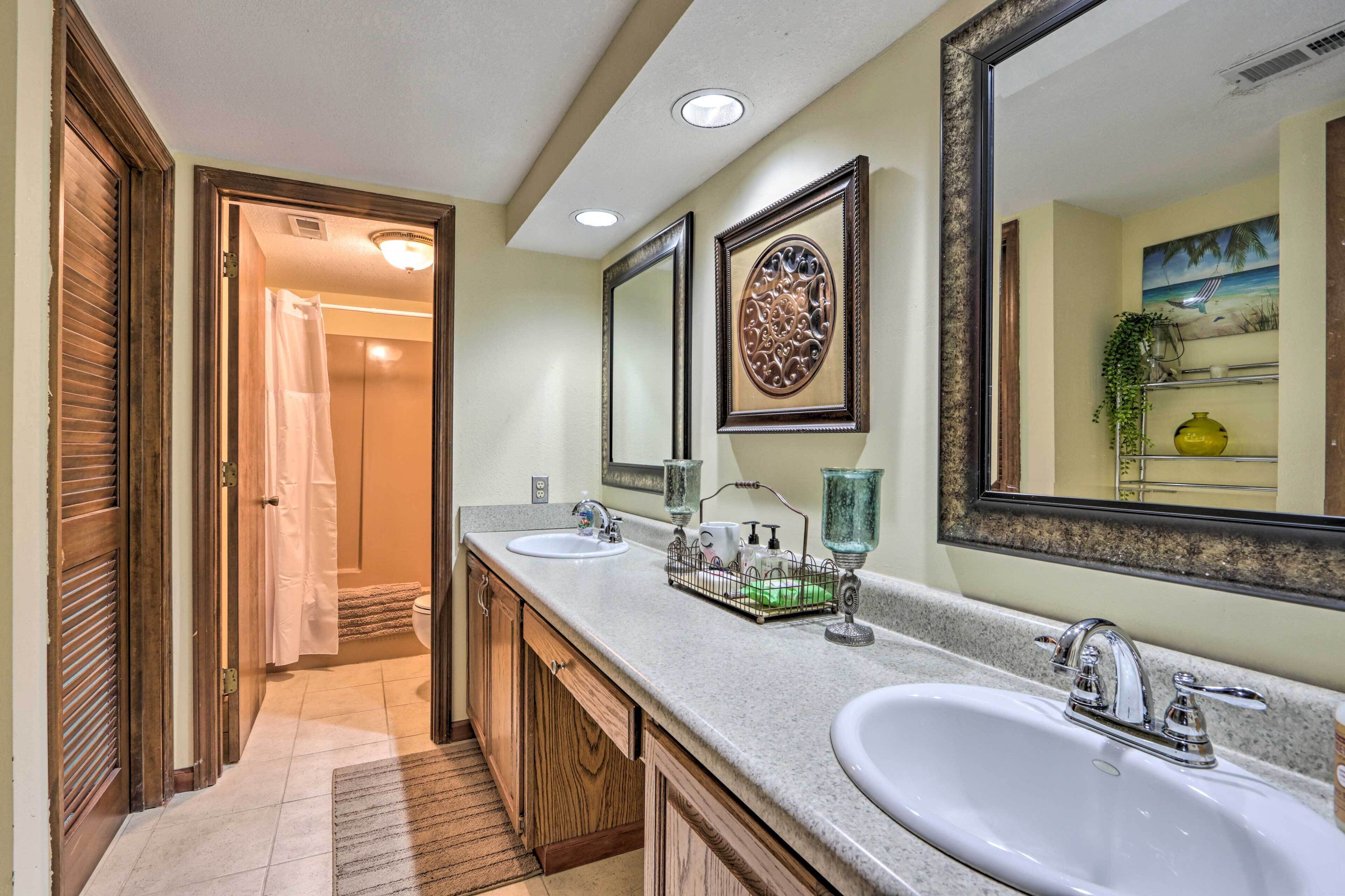 A bathroom with two sinks, wooden cabinets, and a large mirror.