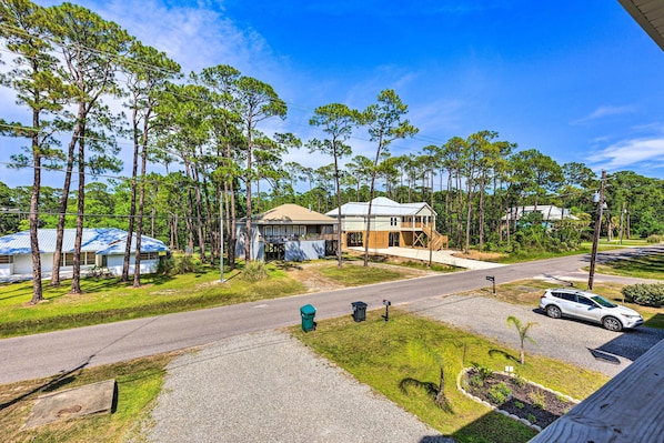 A residential area with a house, a street, and a parked car.