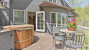 A deck with a hot tub, outdoor seating, and a potted plant. - Enchanting Tryon Home w/ Hot Tub ~ 14 Mi to Tiec! (Tryon)