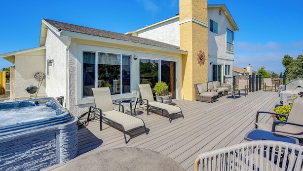 Una casa con jacuzzi, mobiliario exterior y terraza.