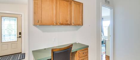 A kitchen with wooden cabinets, a green countertop, and a built-in chair.
