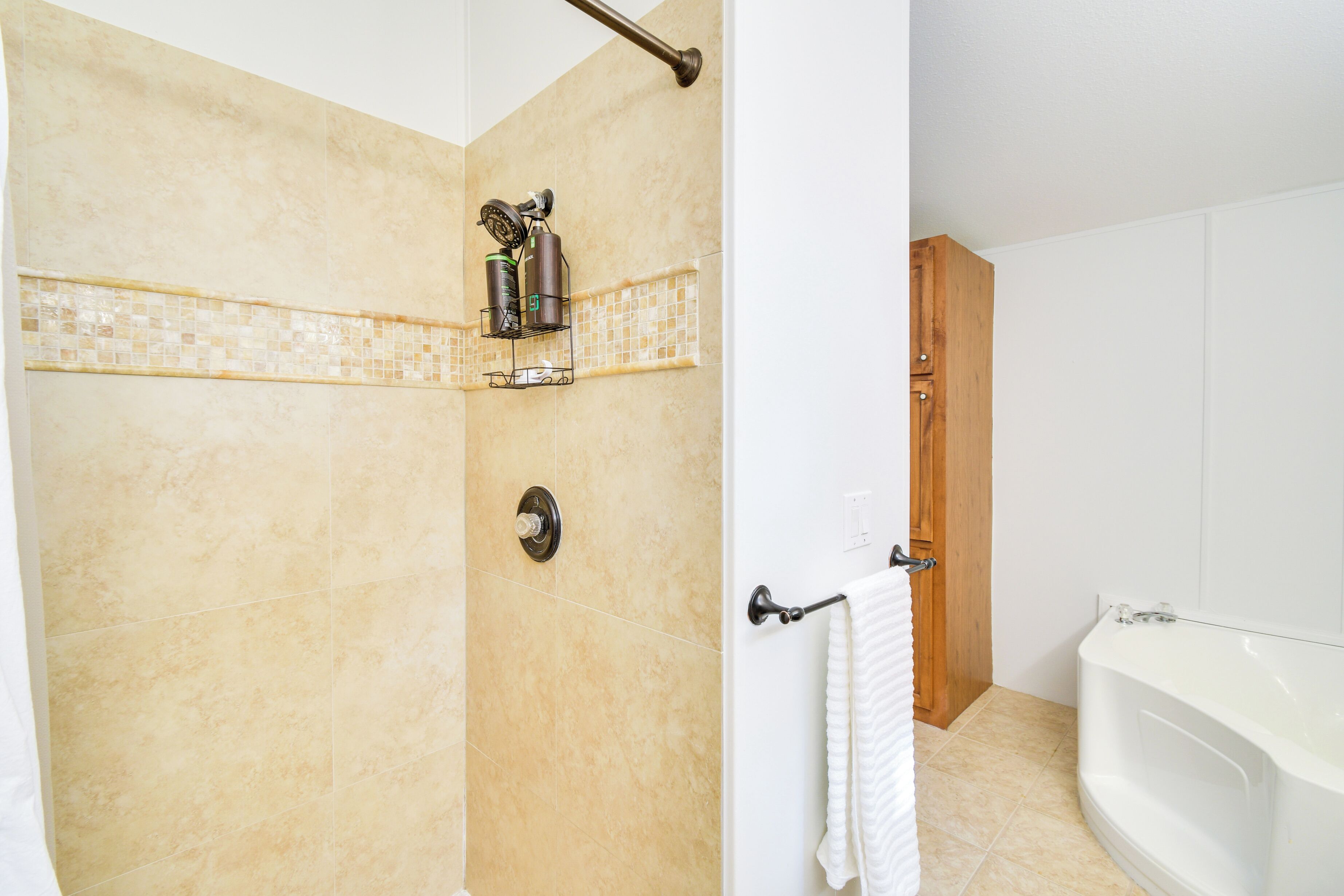 A bathroom with a shower, a bathtub, and a toilet.