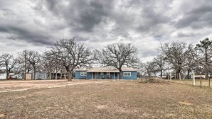 A blue house with a front porch and a large yard.