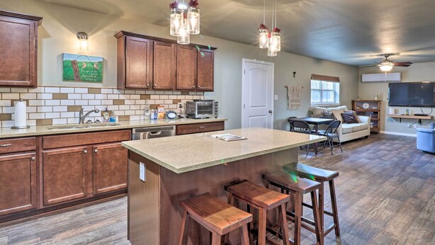 A spacious kitchen with a large island, wooden bar stools, and a dining area with a table and chairs.