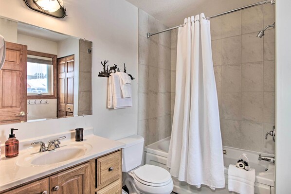 A bathroom with a sink, toilet, and shower.