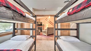 A bunk bed room with a fireplace, a sofa, and a TV. - Biwabik Vacation Rental Near Giants Ridge! (Aurora)