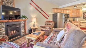 A cozy living room with a fireplace, a sofa, a coffee table, and skis mounted on the wall. - Biwabik Vacation Rental Near Giants Ridge! (Aurora)
