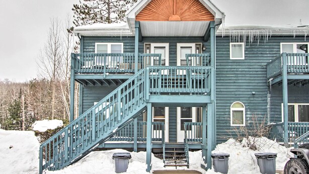 A two-story building with a wooden gable roof, a balcony on the upper floor, and a staircase leading to the entrance. - Biwabik Vacation Rental Near Giants Ridge! (Aurora)