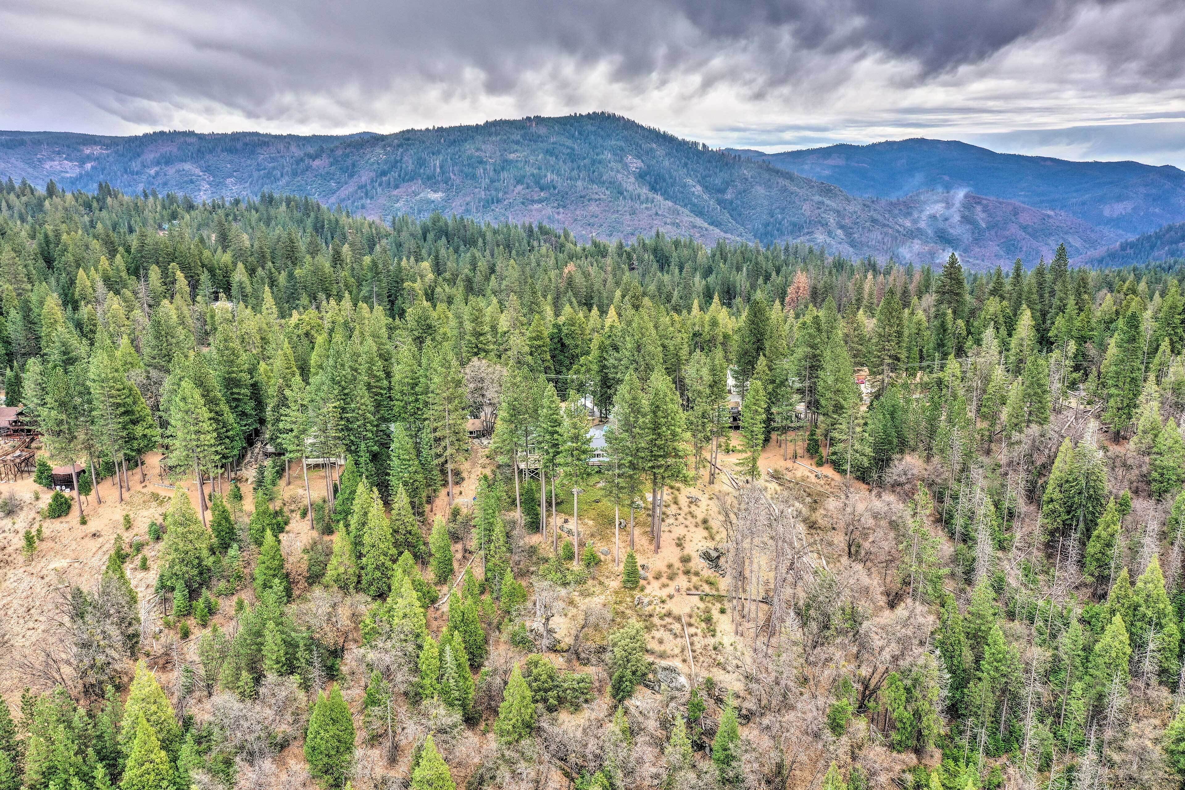Un paysage montagneux bois é, avec une cabane et un petit bâtiment.