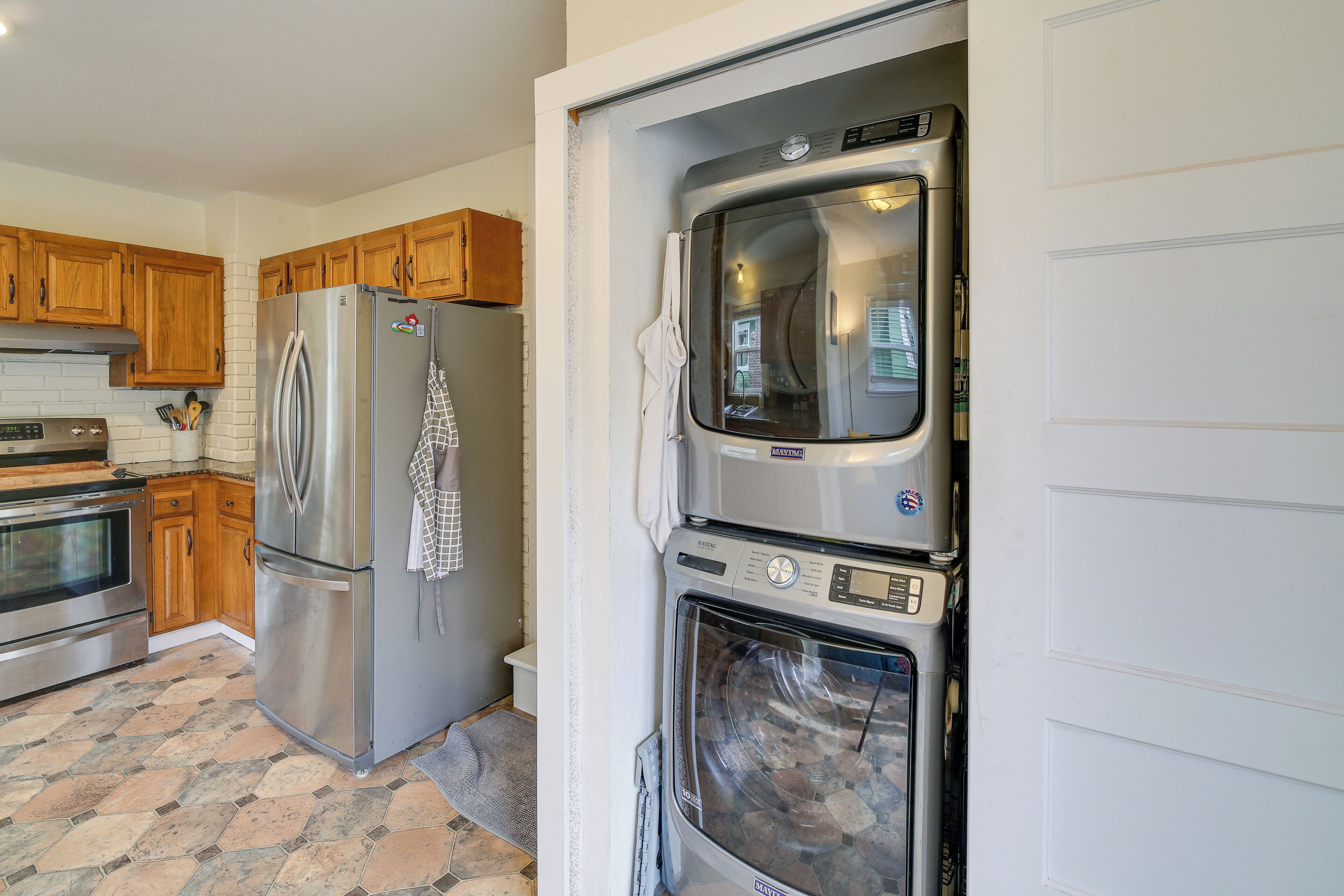 A kitchen with a stainless steel refrigerator, oven, and a built-in microwave.