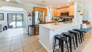 A modern kitchen with a large island, stainless steel appliances, and a view to the outside. - 8 Mi to Charlotte Sports Park: Home w/ Gulf Access (Port Charlotte)