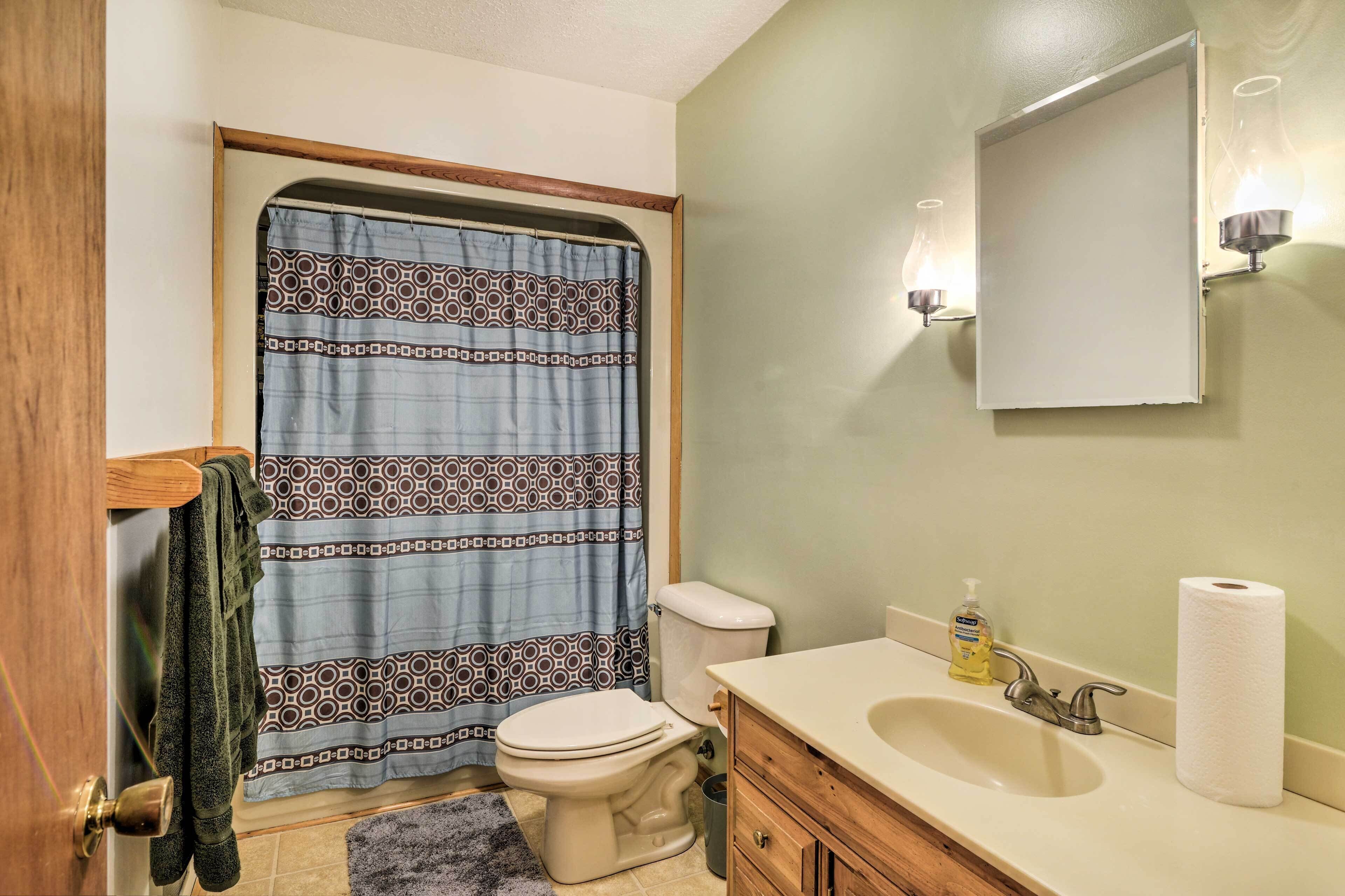 A bathroom with a toilet, sink, and shower curtain.