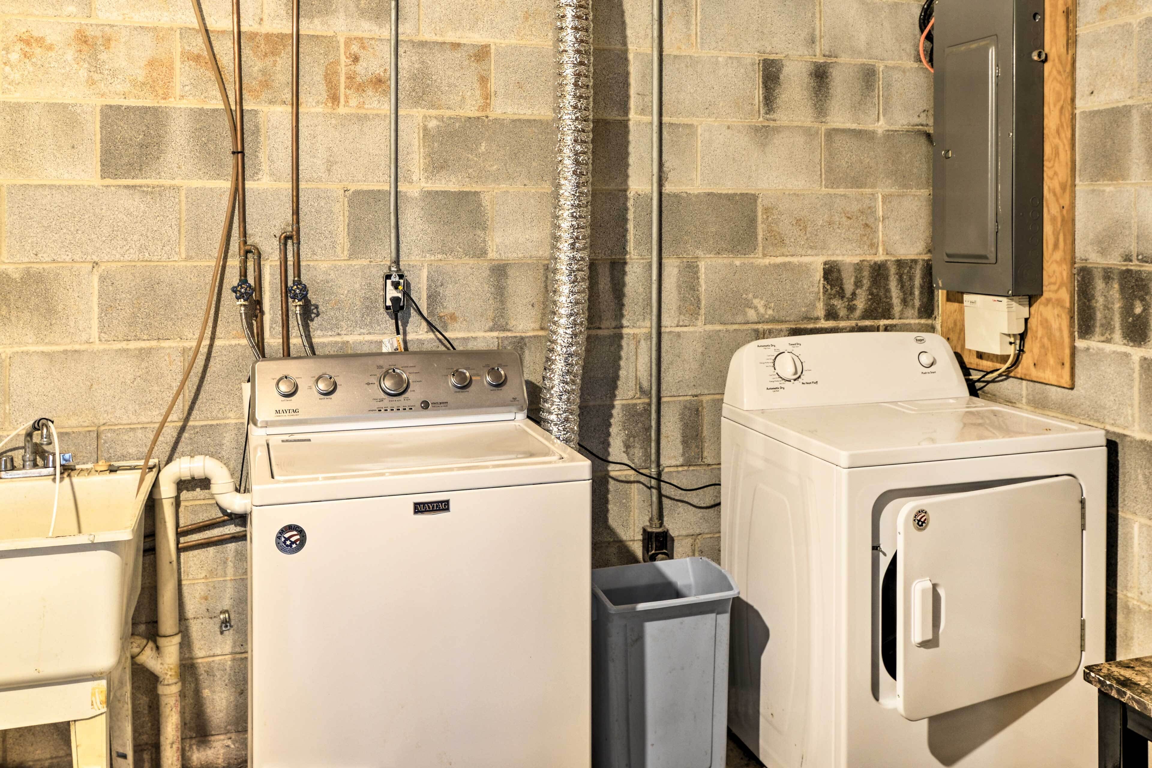 A laundry area with a washing machine and dryer, a sink, and a utility cabinet.