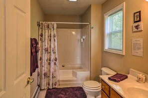 Un baño con bañera, inodoro y lavamanos.